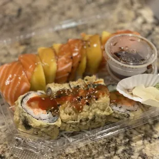 a plastic container with a variety of sushi