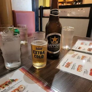 a beer and a menu on a table