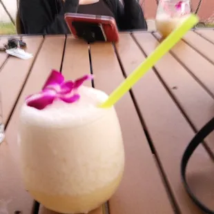 a woman sitting at a table with a drink