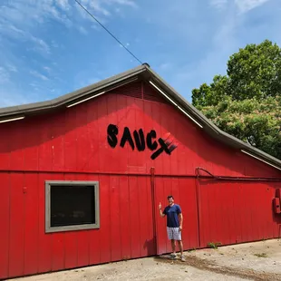 a man standing in front of a red barn