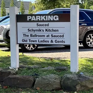 a sign in front of a parking lot