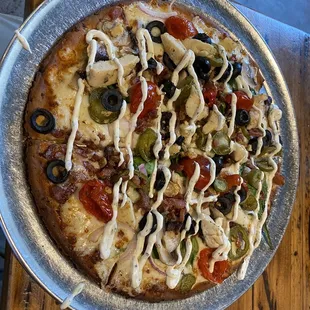 a pizza with olives, peppers, and other toppings