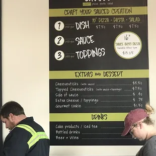 a man and a woman standing in front of a menu