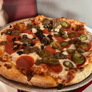 Pizza with pepperoni, olives, meatball, and jalapeños.