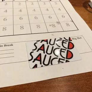 Trivia score sheet and a sauced gift card.