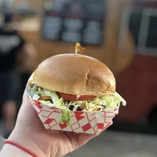 a hand holding a sandwich
