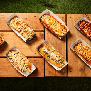 a variety of hot dogs on a picnic table