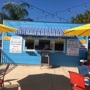 a blue building with yellow umbrellas