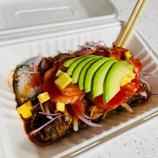 a plate of sushi with chopsticks