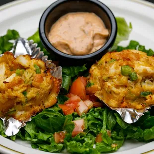 two crab cakes on a bed of lettuce