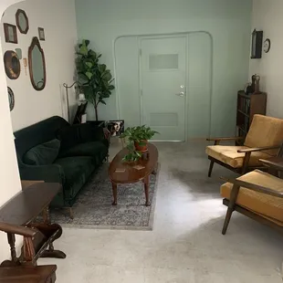 a living room with a green couch and two chairs