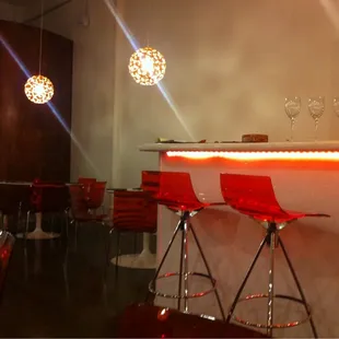 a bar with red chairs