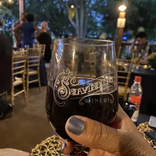 a hand holding a glass of wine