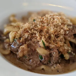 a plate of pasta with meat and mushrooms