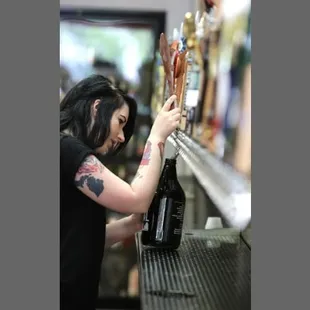 a woman filling a beer at a bar