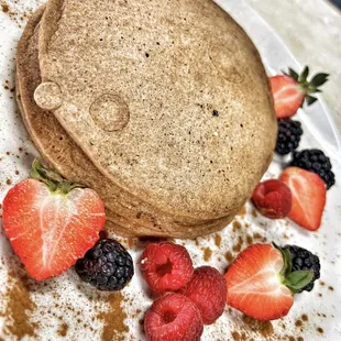 a plate of pancakes and berries