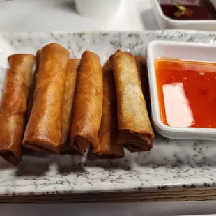a plate of spring rolls with dipping sauce