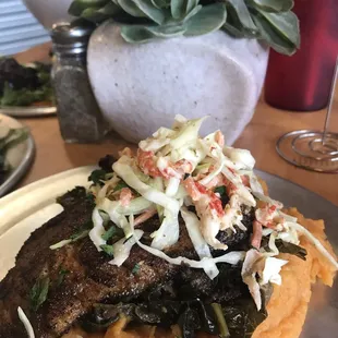 Blackened Red Fish topped with crawfish slaw over Sweet potato mash/ savory greens