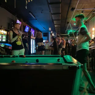 a group of people playing a game of pool