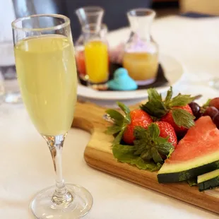 a plate of fruit and a glass of wine