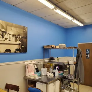 a kitchen with a blue wall and a painting on the wall