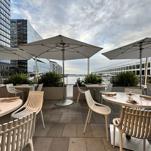 tables and chairs with umbrellas on a rooftop