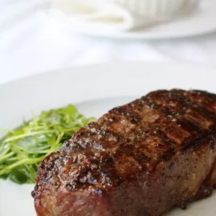 a piece of steak on a white plate