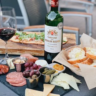 a table with wine, bread, and cheese