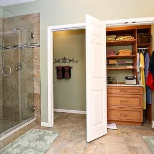 Louisville bathroom remodel featuring walk-in shower with frameless shower door, elegant tile flooring, updated closet storage and more...
