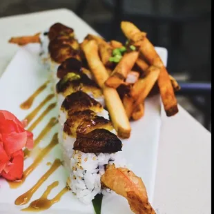 a plate of sushi and french fries