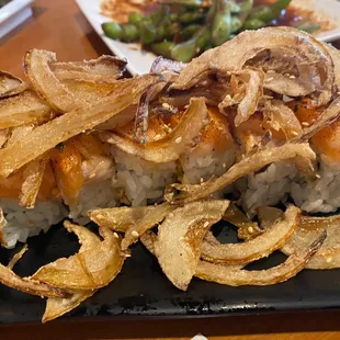 a plate of sushi with onion rings