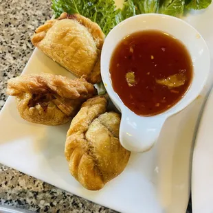 Curry puffs are served with sweet chili sauce