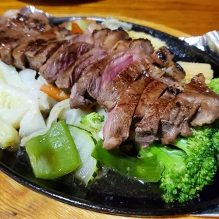 Bangkok Grill: grilled beef on bed of steamed vegetables, served with Thai traditional spicy sauce.