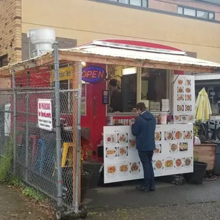 Its tucked between two buildings in a fenced off area