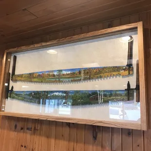 a picture of a river in a frame hanging on a wall