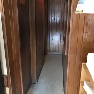 a narrow hallway with wood paneled walls