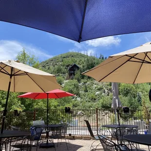 tables and chairs with umbrellas