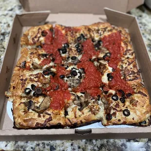 Detroit Pizza with Crumbled sausage, mushrooms and black olives.