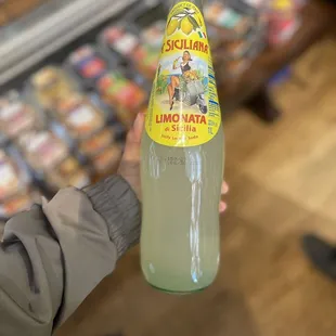 a person holding a bottle of lime water