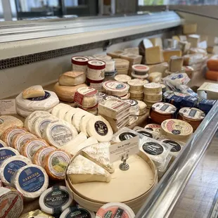 a variety of cheeses in a display case