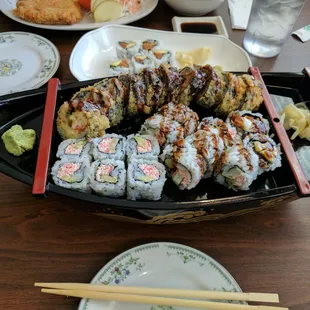 U of M roll (top), California roll (bottom left), and Calamari Tempura Roll (bottom right) in a boat.