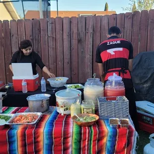 two people preparing food on a table