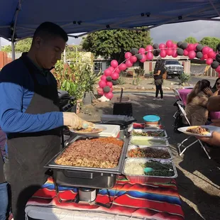 a man serving food under a tent