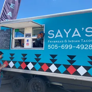 a woman standing in front of a food truck