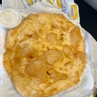Warm, crisp, tasty frybread with honey and powdered sugar on the side.