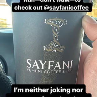 a hand holding a cup of coffee