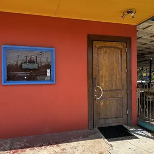 a red building with a wooden door and a blue window