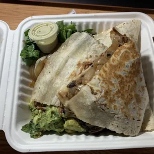 Carnitas quesadilla with sautéed onion, black beans, shredded lettuce, Monterey cheese, and cilantro lime aioli