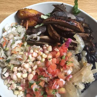 a white bowl filled with rice, beans, and vegetables