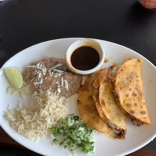 Birria Tacos - brisket tacos served with consume, rice and beans. AMAZING